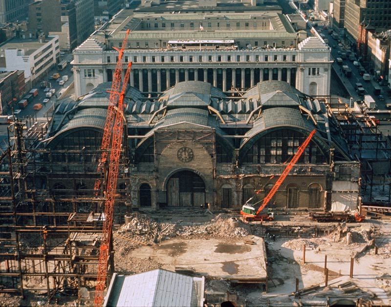 The demolition of penn station in the early 1960s. In the background, the james a. Farley post office, also designed by mckim, mead & white, is viewed as a successor, though plans have moved slowly