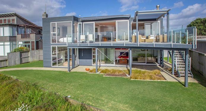 A home on Omaha Beach, north of Auckland, illustrates the kind of modern design and top-end construction now common among vacation homes, popularly called baches