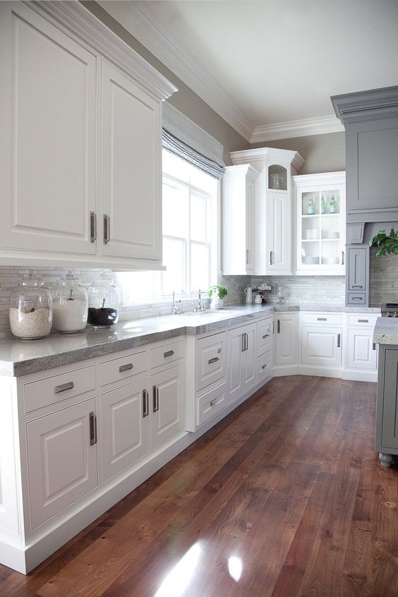 Granite accents on white kitchen cabinets paired with light gray