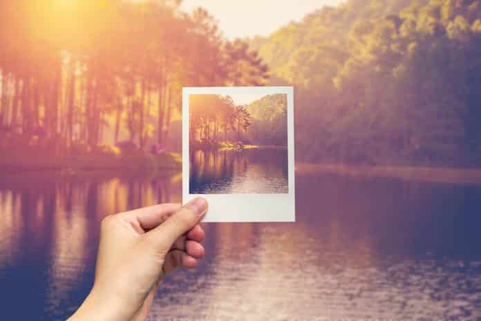 hand hold instant photo Pond water and sunrise with vintage effect.