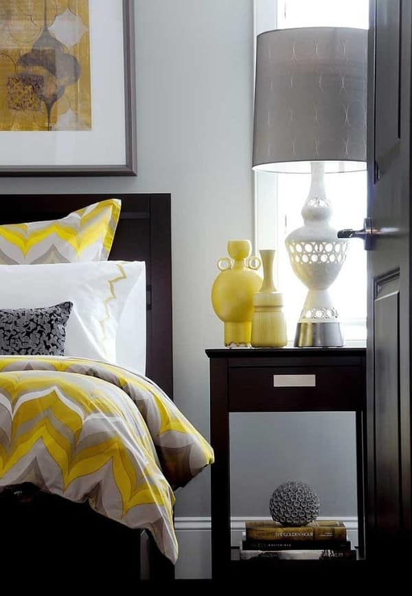 Bedding and vases add pops of yellow to the gray bedroom