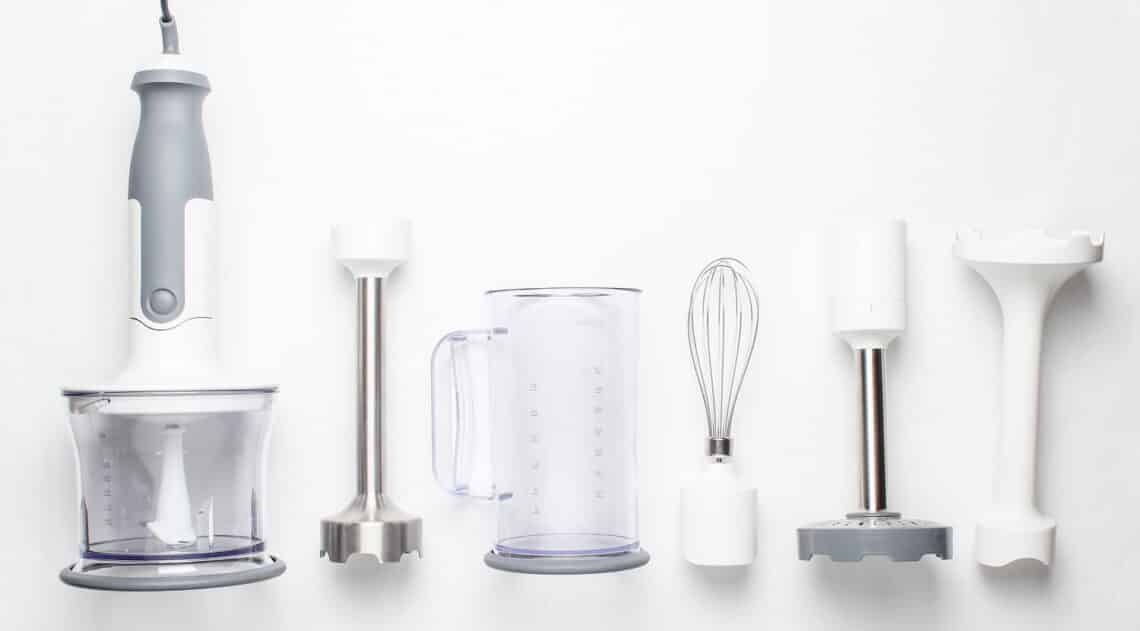 Electric hand mixer. Set of nozzles and containers for blender on white background. Top view, flat lay
