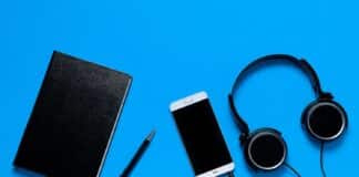 Mobile Phone, Headphones, Notepad And Pen On A Blue Background