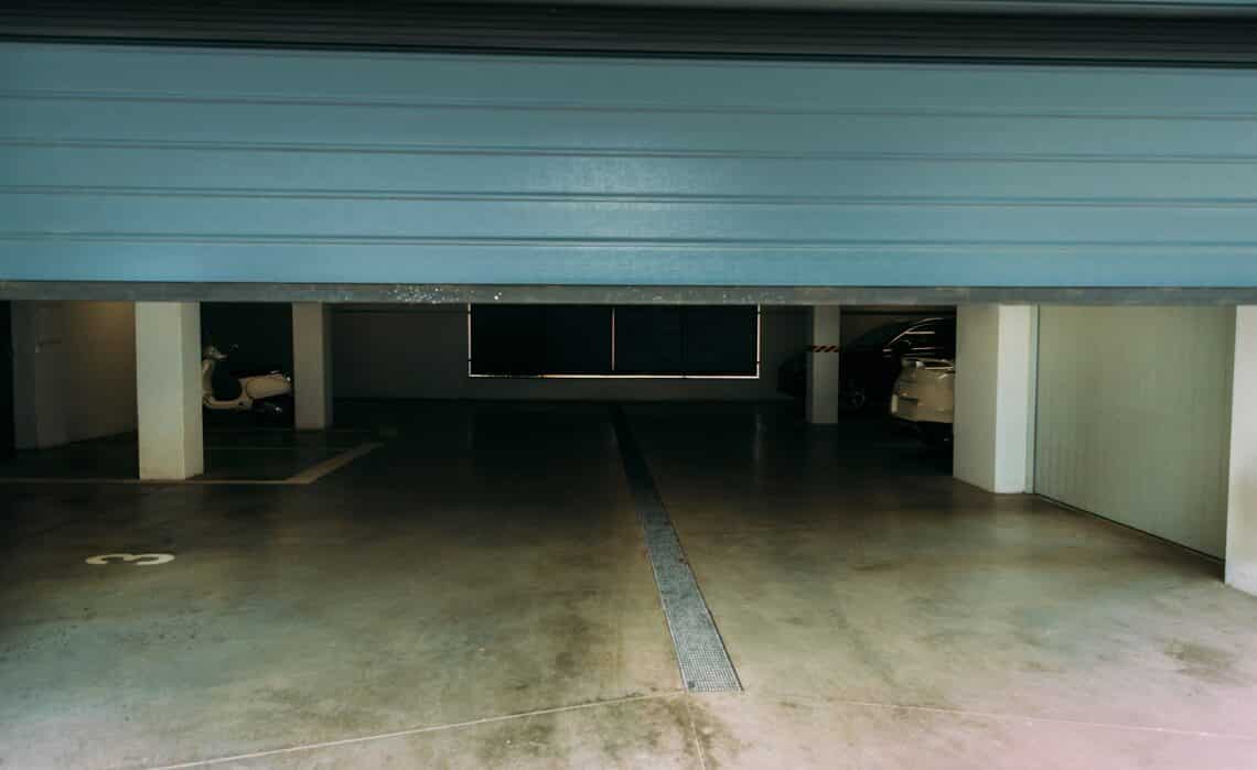 Photo of an automatic closing blue pvc door of a garage with a remote controller.