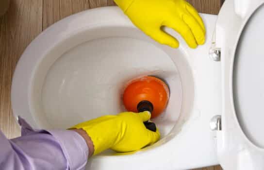 Man cleaning overflowing broken toilet. Clogged toilet