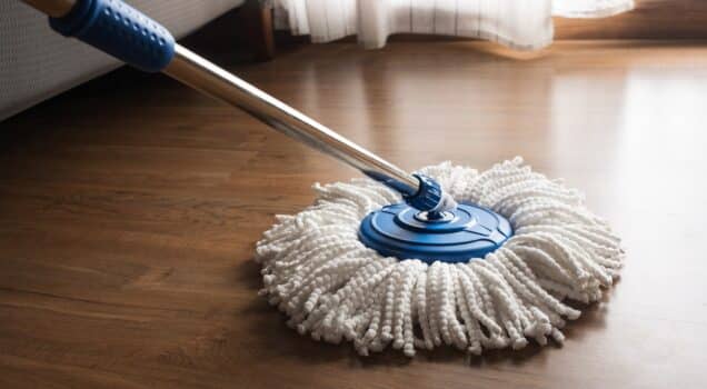 Mop cleaning on wooden floor in house