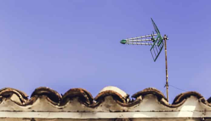 Television antenna on the old roof with blue sky background in Andalucia, Spain