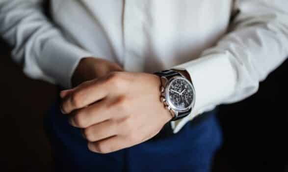 Rehearsal preparation. Groom's watches on hand. High angle view of groom, fixing his watches before wedding.