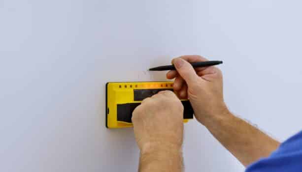 Man hand is scanning wall by uses multi-sense technology to find studs more accurately through difficult surfaces soft focus