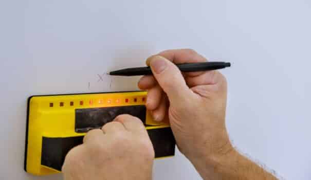 Digital detector man hand is scanning wall by sensors precision stud finder wooden beams soft focus
