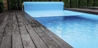 Automatic swimming pool covering system, safely protect children and pets from accidental contact with water, home and cottage equipment, copyspace, place for text, outdoor exterior