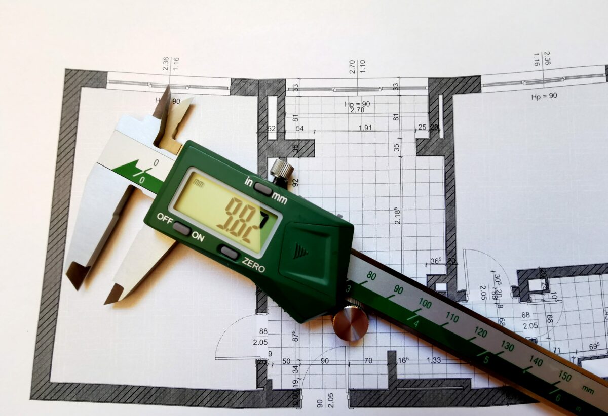 Digital caliper sitting on an apartment blueprint plan