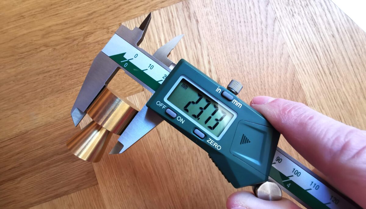 Digital caliper used to measure a brass knob