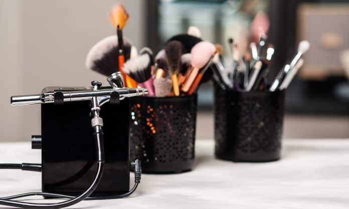 Beauty and fashion. Makeup tools and brushes on artist workplace. Makeup products set. Beauty salon treatment. Airbrush for makeup. Modern beauty women salon.