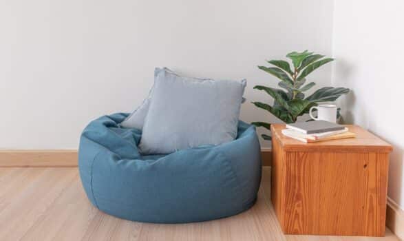 Blue bean bag in a clear living room with wooden floor and clear white wall.