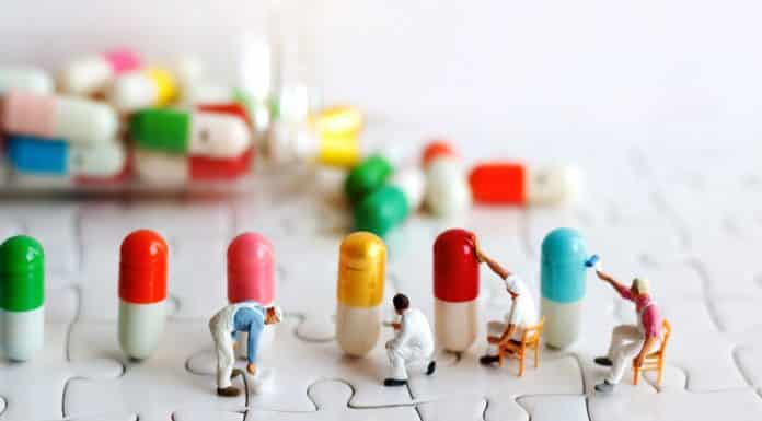 Miniature people: Workers team brush painting Medicinal capsules. Healthcare, Medical and business concept.