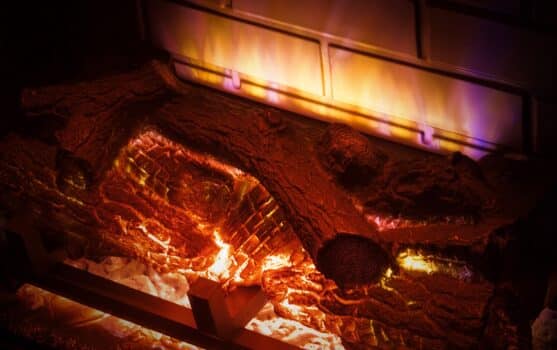 Electric imitation of fireplace with firewood extreme closeup