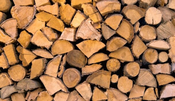Material for heating the house. Preparation of firewood for the winter. Background of firewood. A pile of firewood.