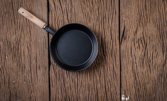 Top view black pan on wood background