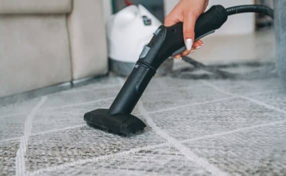 Woman cleaning the carpet with a steam cleaner