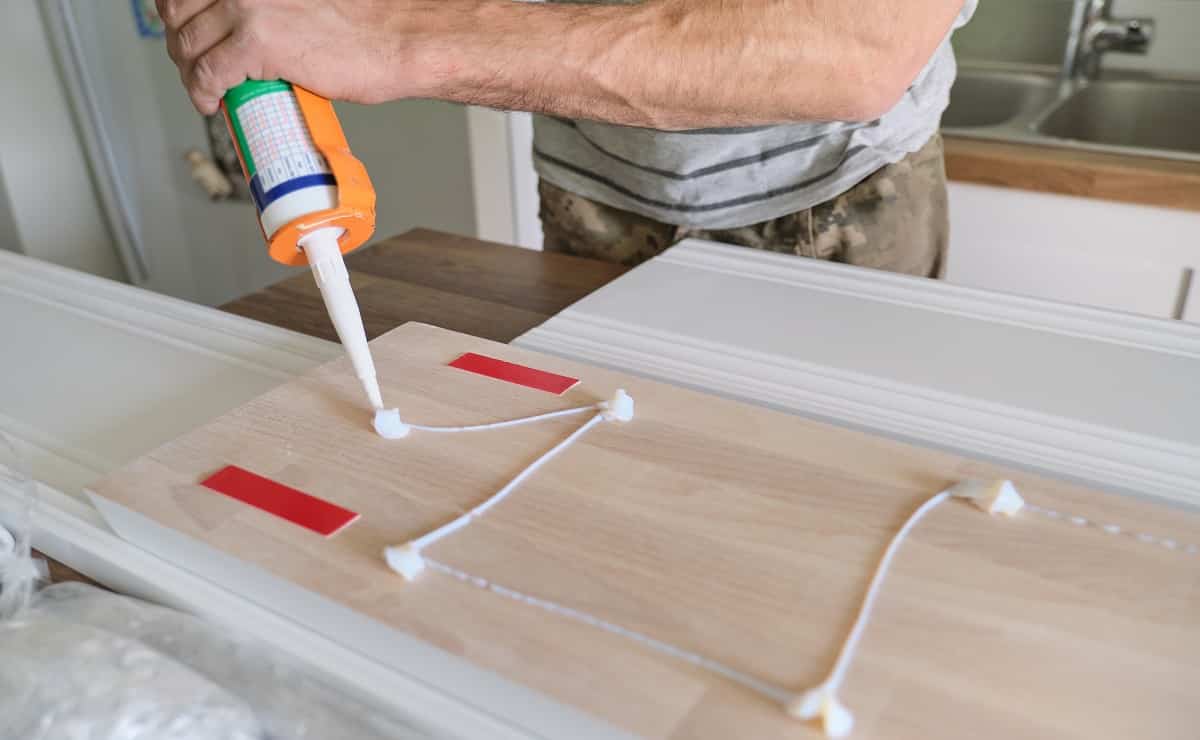 Carpenter male using construction glue when working with best glue for mdf