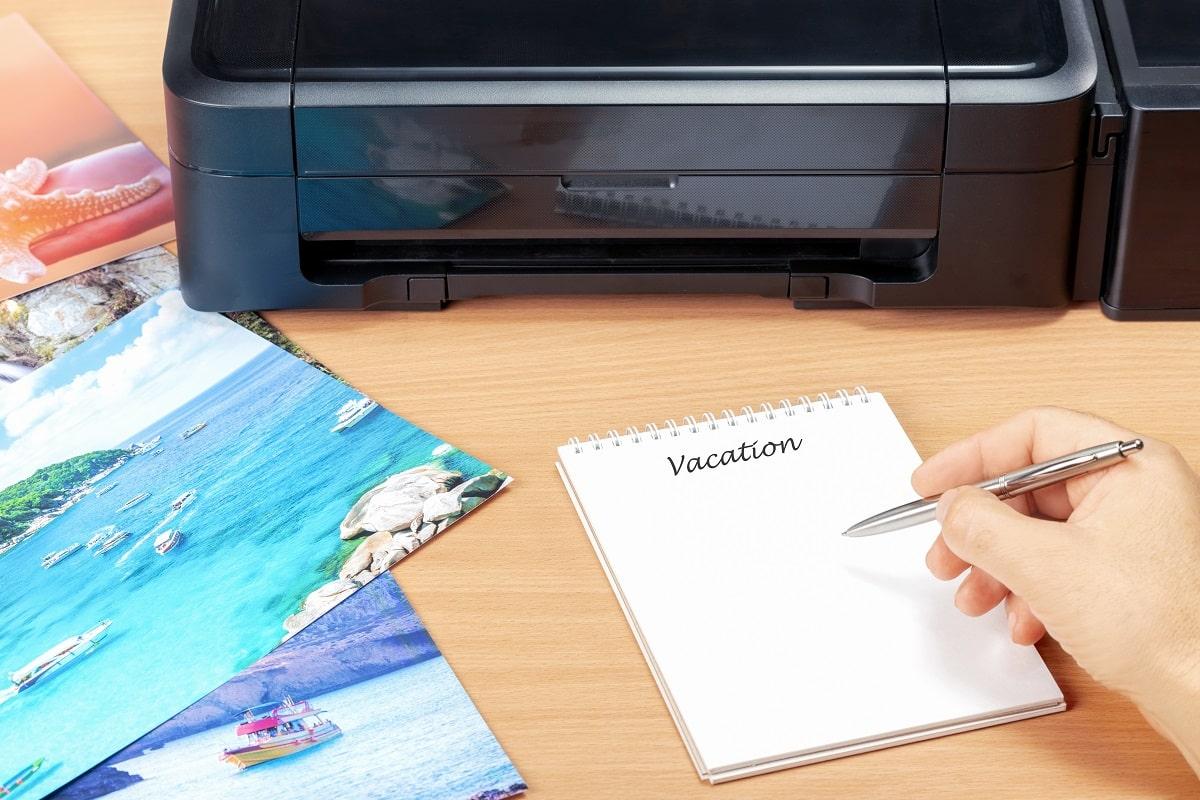 Man planning vacation with photos he printed after summer vacation. Concept planning summer vacation in beautiful place.
