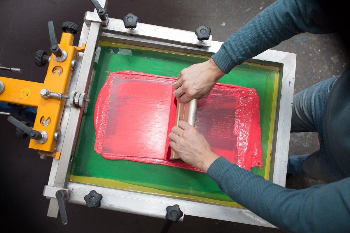 Silk screen printing. Serigraphy. Color paints and fabric. Plastisol paint and squeegee. What does screen printing involve.