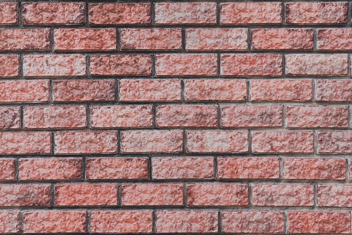 Red brick wall. Horizontal brickwork. Surface of masonry wall. Texture. Block-in-course masonry wall texture. Brick veneer siding.