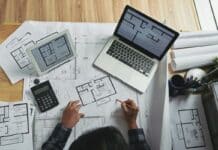 Professional architect making corrections in apartment blueprint, view from above. Do You Need A Specific Laptop For Architecture.