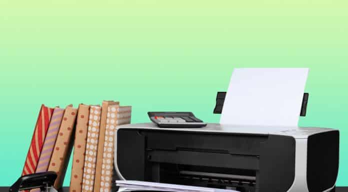 Home laser printer on desk against green background, close up. Why Laser Printer Is Better Than Inkjet.