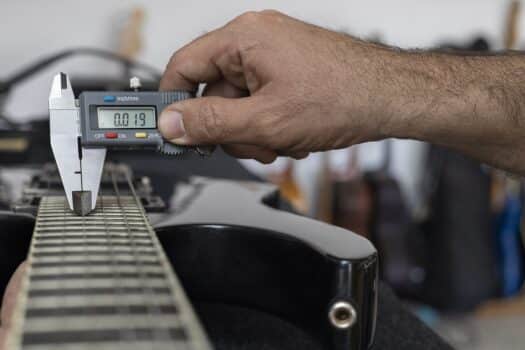 Latin american luthier calibrates the strings of an electric guitar with a digital vernier. Unrecognizable. Guitar concept, calibration, instrument. How to read digital calipers in inches final words .