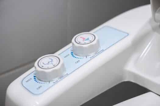 Toilet flush bowl with electronic water injection and automatic flushing system in hotel bathroom, modern restroom technology in japan. Attachable bidets for toilets.