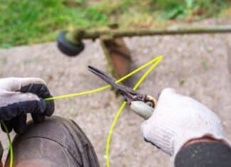 A gardener with a pruner cuts a piece of fishing line for a gas mower. Spring lawn mowing, lawn care. How To String A Weed Eater.