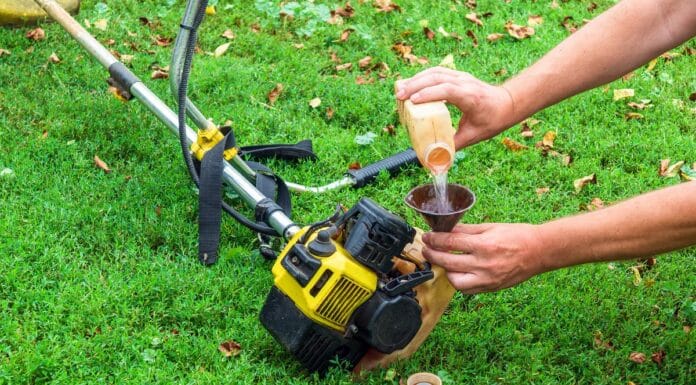 Worker pours gasoline into a trimmer or lawn mower that lies on the grass before haymaking. How much gas does a weed eater use per hour 1.