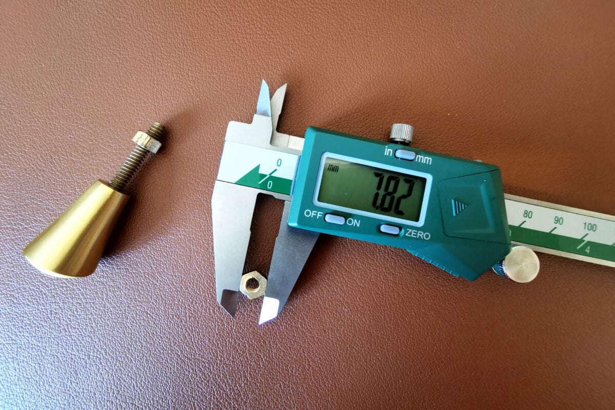 Digital caliper measuring brass pieces