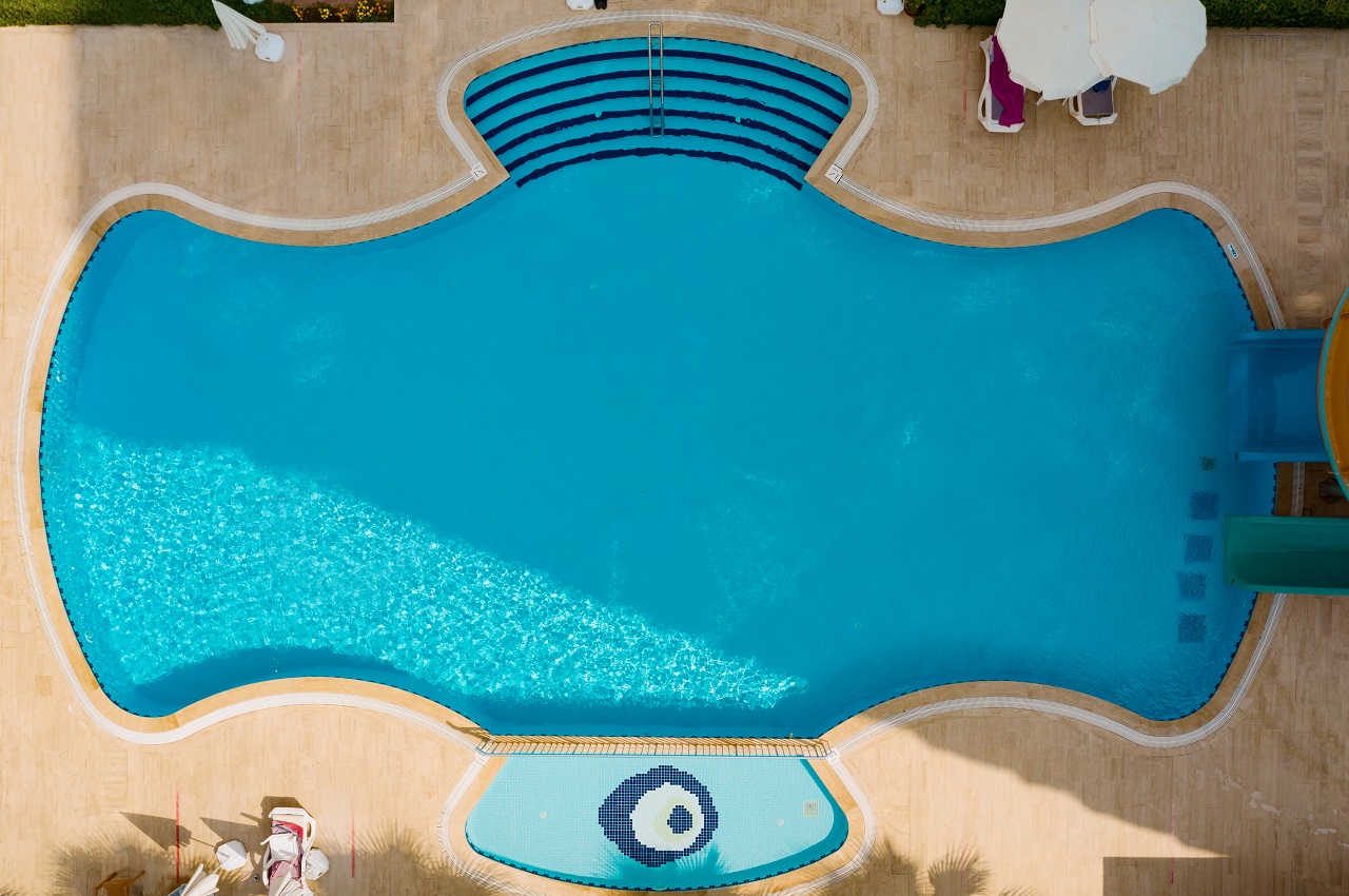 Aerial view of swimming pool outside ،tel. Beautiful pool ready to ،liday tourists. Irregularly-shaped swimming pool.