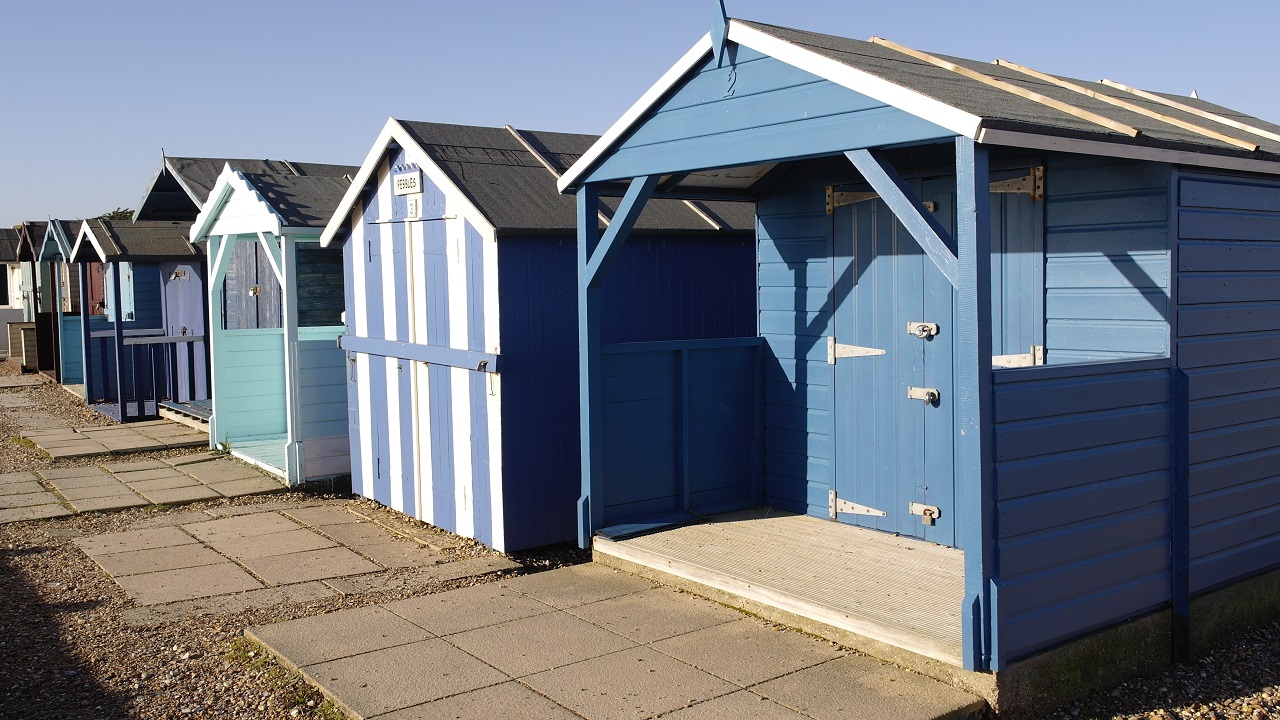 A row of blue beach huts on the seafront at littlehampton, west sussex. Uk. Sheds with paver foundation.