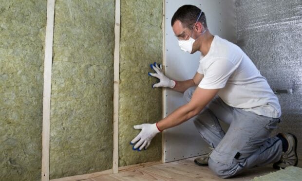 Man working on soundproofing  the wall