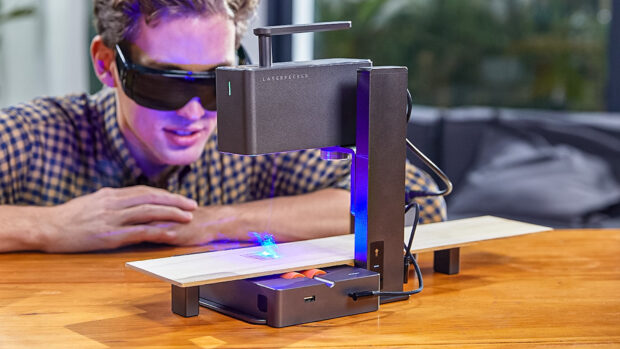 Man watching a portable laser engraving wood