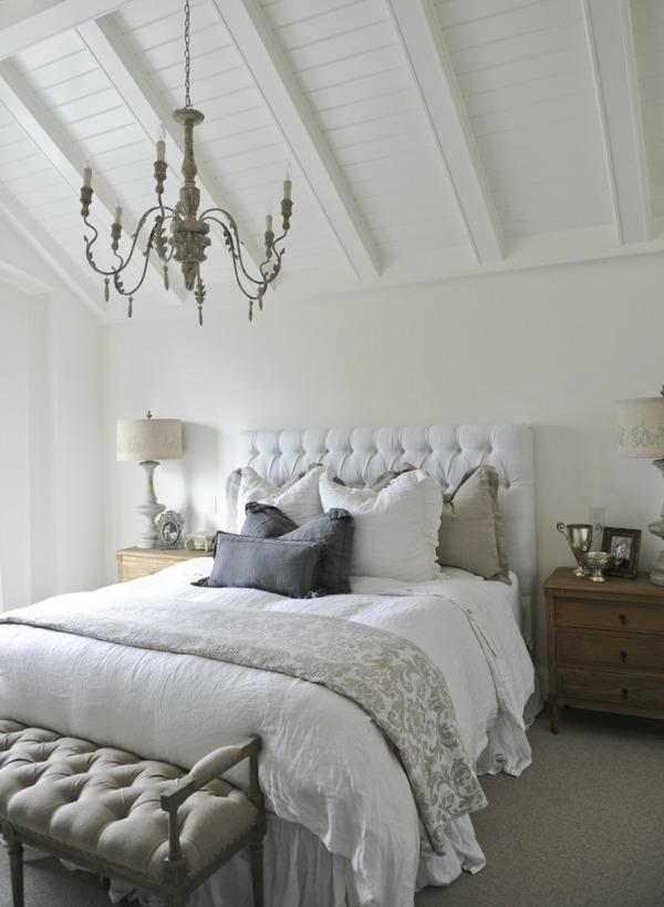 Luxurious bedroom with subtle taupe details on pillows and footstool.